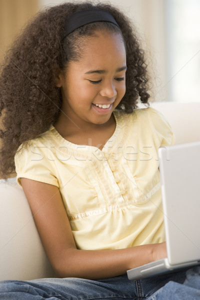ストックフォト: 若い女の子 · リビングルーム · ラップトップを使用して · 笑みを浮かべて · 子供 · インターネット