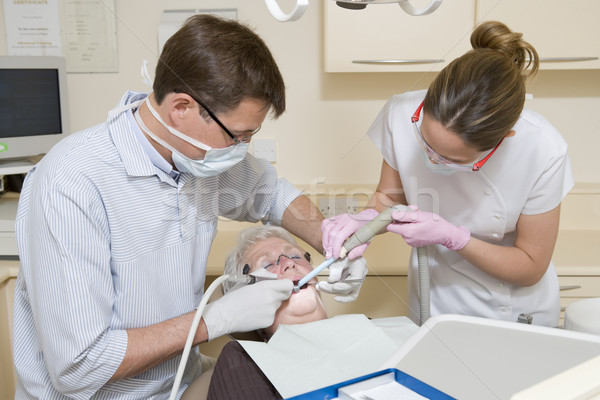 Dentist and assistant in exam room with woman in chair Stock photo © monkey_business