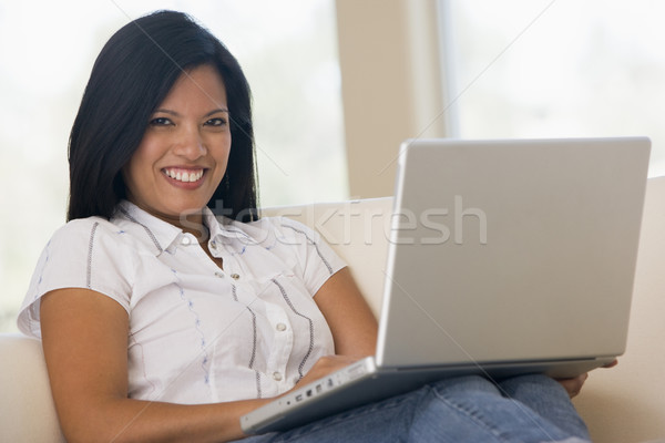 Woman in living room using laptop smiling Stock photo © monkey_business