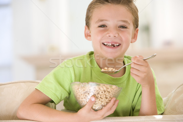 Stock photo: Young boy eating cereal in living room smiling