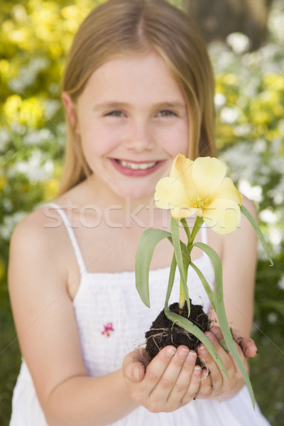 Stock photo: Young girl outdoors holding flower smiling