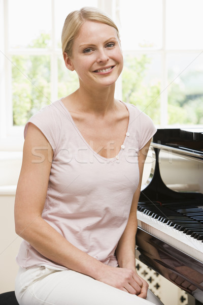 Woman sitting at piano and smiling Stock photo © monkey_business
