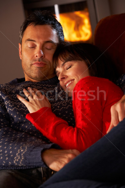 Middle Aged Couple Cuddling On Sofa By Cosy Log Fire Stock photo © monkey_business