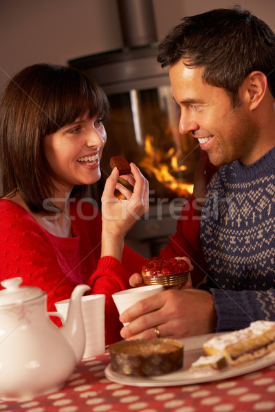 Couple Enjoying Tea And Cake By Cosy Log Fire Stock photo © monkey_business