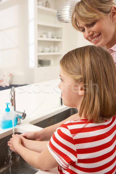 Mother And Daughter Washing Hands At Kitchen Sink Stock photo © monkey_business