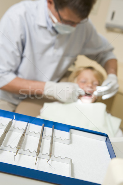 Dentist in exam room with young boy in chair Stock photo © monkey_business