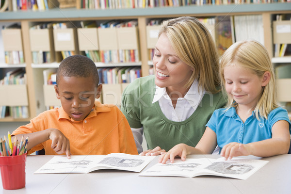 Kindergarten teacher helping students with reading skills Stock photo © monkey_business