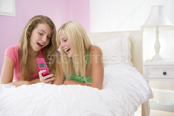 Tinilányok ágy mobiltelefon boldog barátok tini Stock fotó © monkey_business
