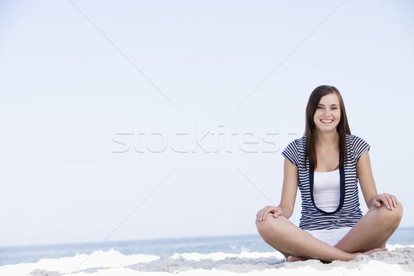 Fiatal nő ül tengerpart óceán mögött nő Stock fotó © monkey_business