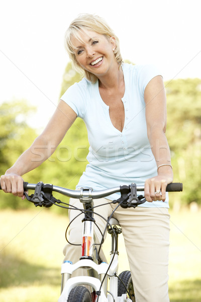 Portret rijpe vrouw paardrijden cyclus platteland gelukkig Stockfoto © monkey_business