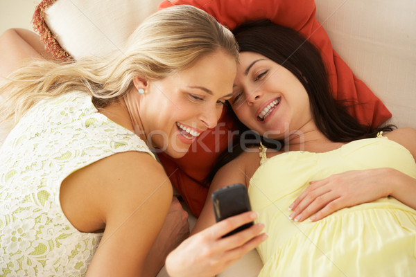 Kettő női barátok kanapé olvas szöveges üzenet Stock fotó © monkey_business