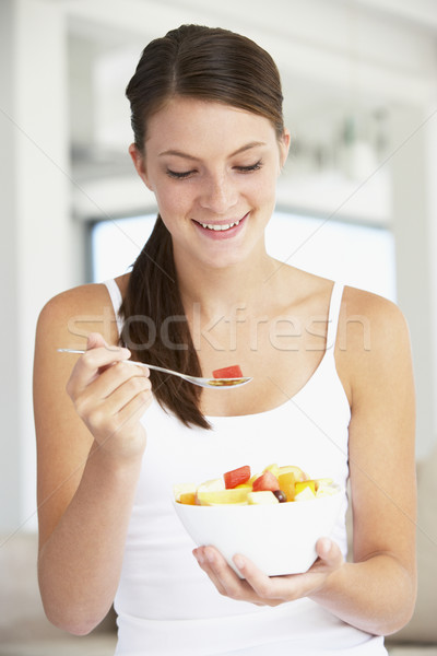 Fiatal nő eszik friss gyümölcs saláta nő otthon Stock fotó © monkey_business