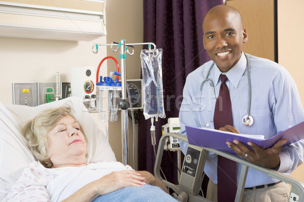 Doctor Making Notes About Senior Woman Lying In Hospital Bed Stock photo © monkey_business