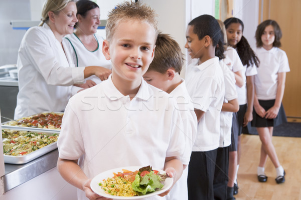 Schoolboy holding plate of lunch in school cafeteria Stock photo © monkey_business