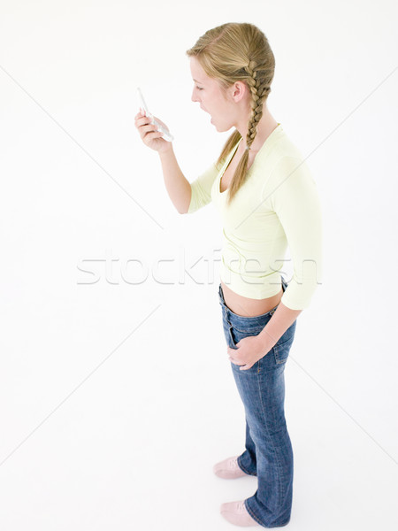 Genç kız bakıyor cep telefonu şok kız çocuklar Stok fotoğraf © monkey_business
