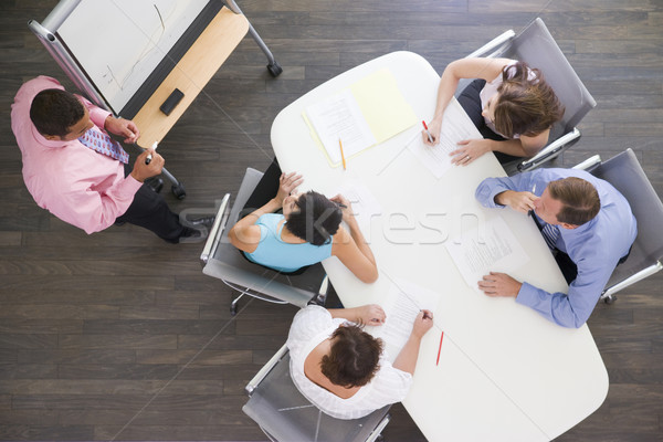 Vier Geschäftsleute Sitzungssaal Tabelle beobachten Präsentation Stock foto © monkey_business