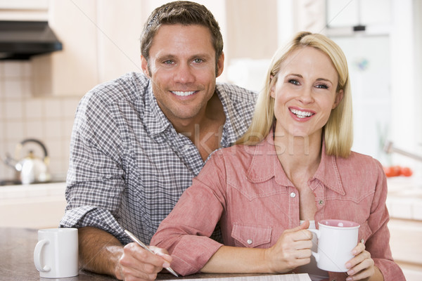 Couple in kitchen with newspaper and coffee smiling Stock photo © monkey_business