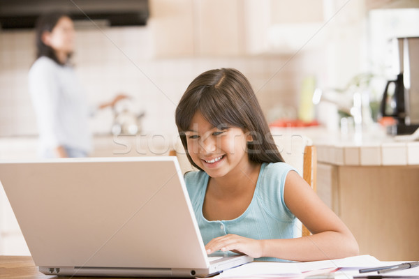 Young girl in kitchen with laptop and paperwork smiling with wom Stock photo © monkey_business