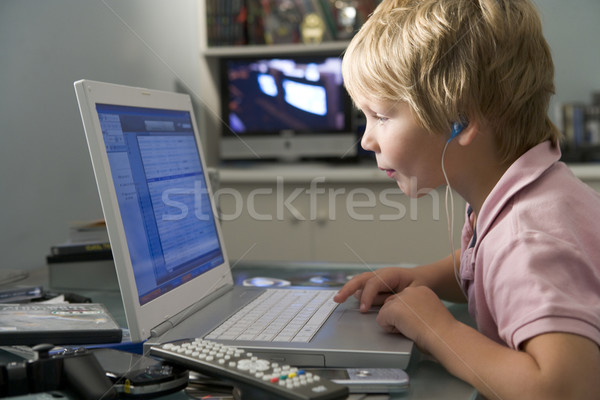Młody chłopak sypialni za pomocą laptopa słuchania mp3 player muzyki Zdjęcia stock © monkey_business