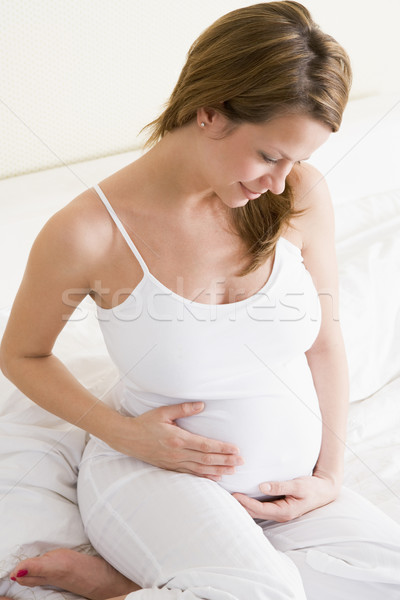 Femeie gravida şedinţei pat zâmbitor femeie fericit Imagine de stoc © monkey_business