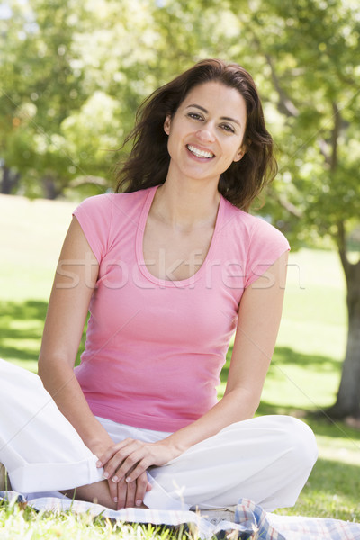 Stock photo: Woman sitting outdoors smiling