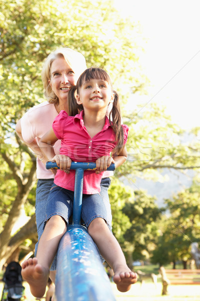 Stock photo: Grandmother And Granddaughter Riding On See Saw In Playground