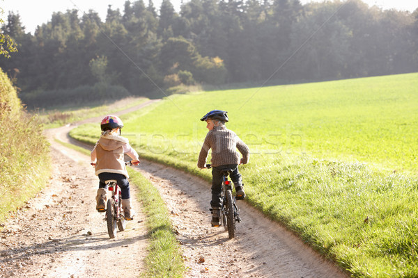 Two young children ride bicycles in park Stock photo © monkey_business