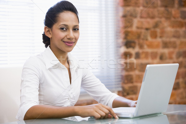 Businesswoman in office with laptop smiling Stock photo © monkey_business