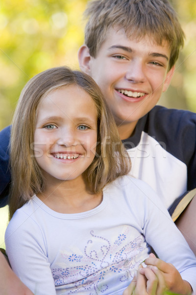 Stock photo: Brother and sister sitting outdoors smiling
