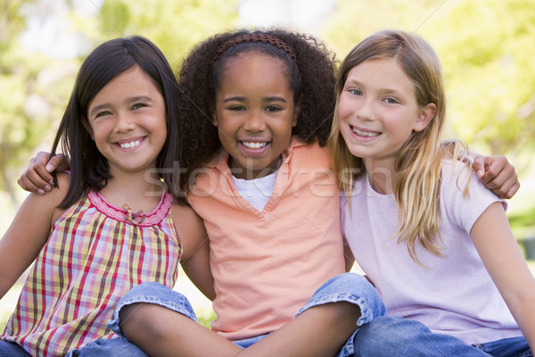 Három fiatal lány barátok ül kint mosolyog Stock fotó © monkey_business