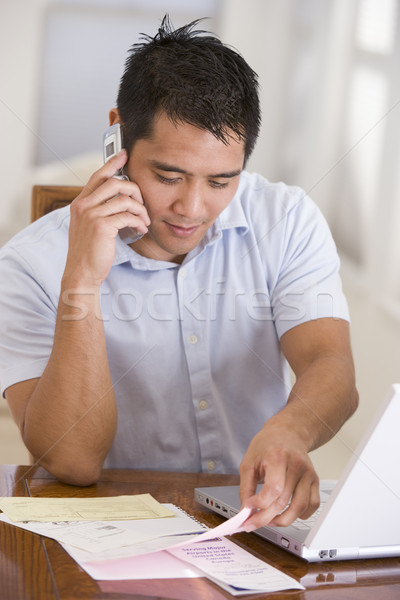 Homme salle à manger téléphone cellulaire utilisant un ordinateur portable portable téléphone Photo stock © monkey_business