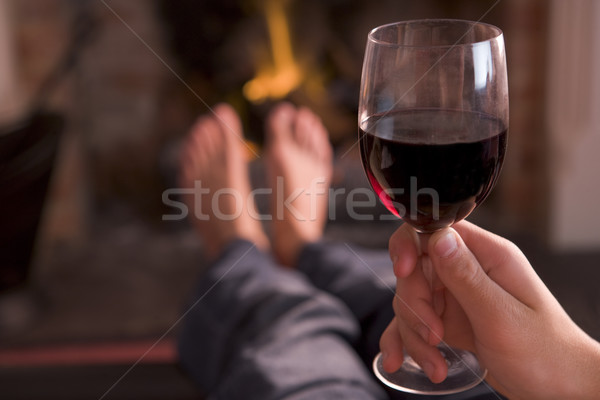 Feet warming at fireplace with hand holding wine Stock photo © monkey_business