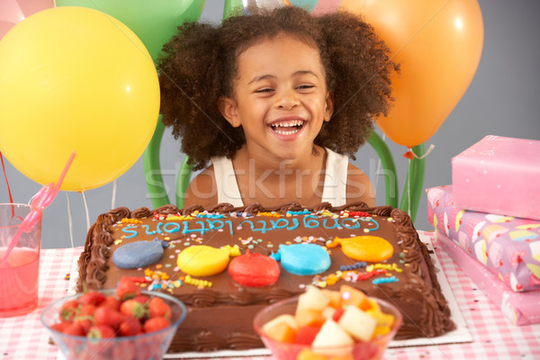 Stock photo: Young girl with birthday cake and gifts at party