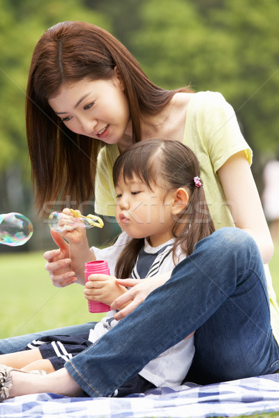 Chinese Mother With Daughter In Park Blowing Bubbles Stock photo © monkey_business
