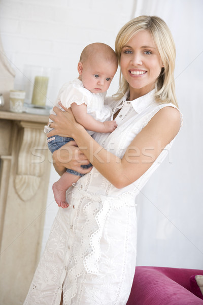 Mother in living room holding baby smiling Stock photo © monkey_business