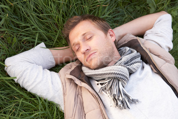 Young man napping alone on grass Stock photo © monkey_business