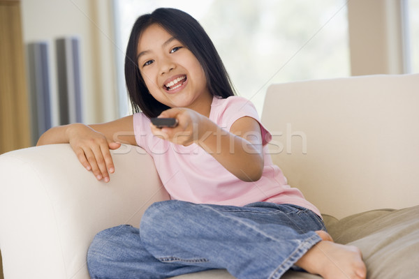 Foto stock: Jovem · sala · de · estar · controle · remoto · sorridente · menina · televisão