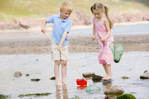 Brother and sister at beach with nets and pail Stock photo © monkey_business