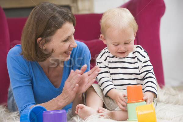 Mother in living room playing with baby smiling Stock photo © monkey_business