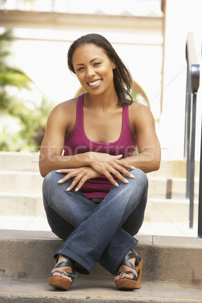 Stock photo: Young Woman Sitting On Steps Of Building