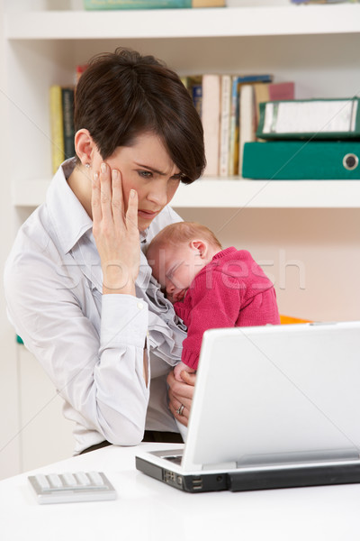 Stock photo: Stressed Woman With Newborn Baby Working From Home Using Laptop