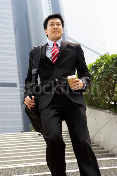 Chinese Businessman Rushing Down Steps Carrying Bag And Takeaway Stock photo © monkey_business