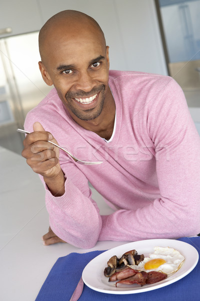 Középkorú férfi eszik egészségtelen sült reggeli étel Stock fotó © monkey_business