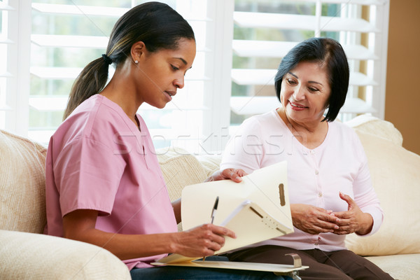 Nurse Discussing Records With Senior Female Patient During Home  Stock photo © monkey_business