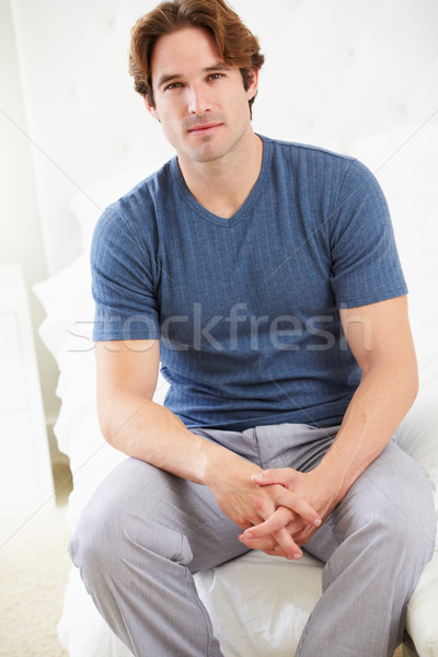 Człowiek posiedzenia bed piżama szczęśliwy Zdjęcia stock © monkey_business