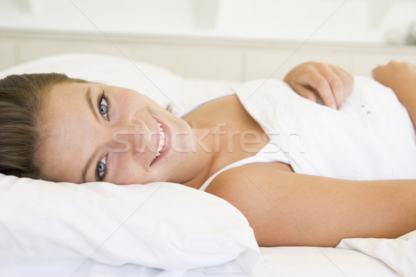 Stock photo: Woman lying in bed smiling