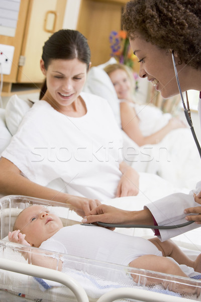Doctor checking baby's heartbeat with new mother watching and sm Stock photo © monkey_business
