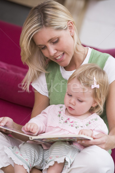Mother in living room reading book with baby smiling Stock photo © monkey_business