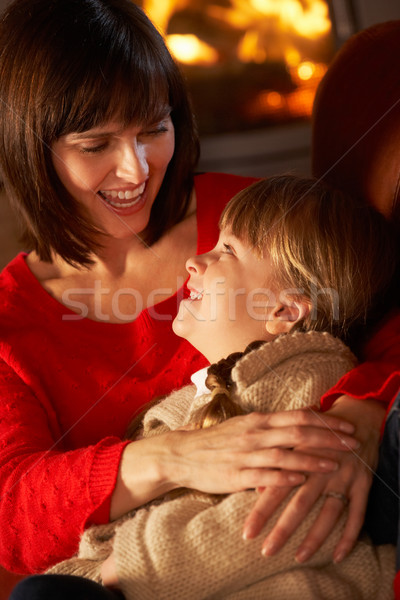 Mother And Daughter Relaxing On Sofa By Cosy Log Fire Stock photo © monkey_business