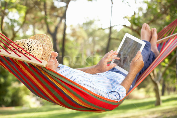 Foto stock: Senior · homem · relaxante · maca · ebook · feliz